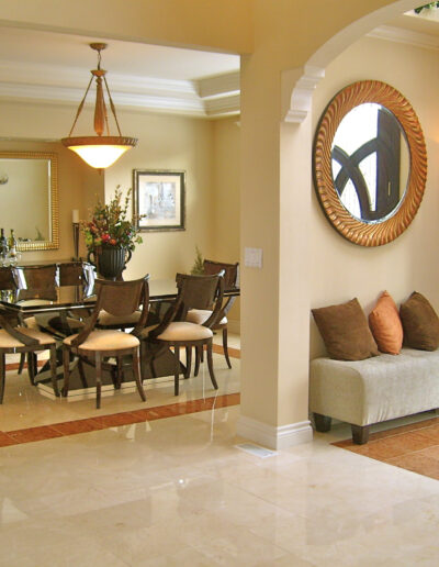 Elegant dining area with adjacent sitting space featuring bright lighting, tiled flooring, classic furniture, and decorative elements.