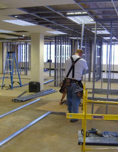 Construction worker surveying an interior space undergoing renovation.