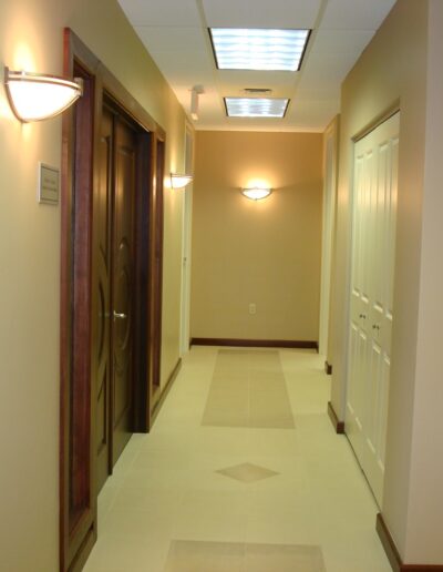A well-lit, empty corridor with doors on either side.