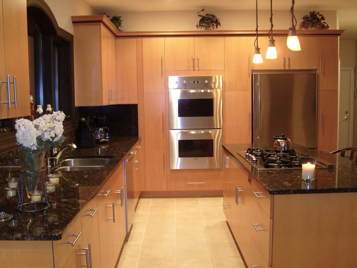 Modern kitchen with wooden cabinets, stainless steel appliances, and black granite countertops.